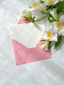 a pink envelope with white flowers on it
