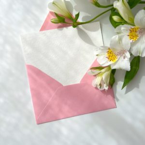 a pink envelope with white flowers on it